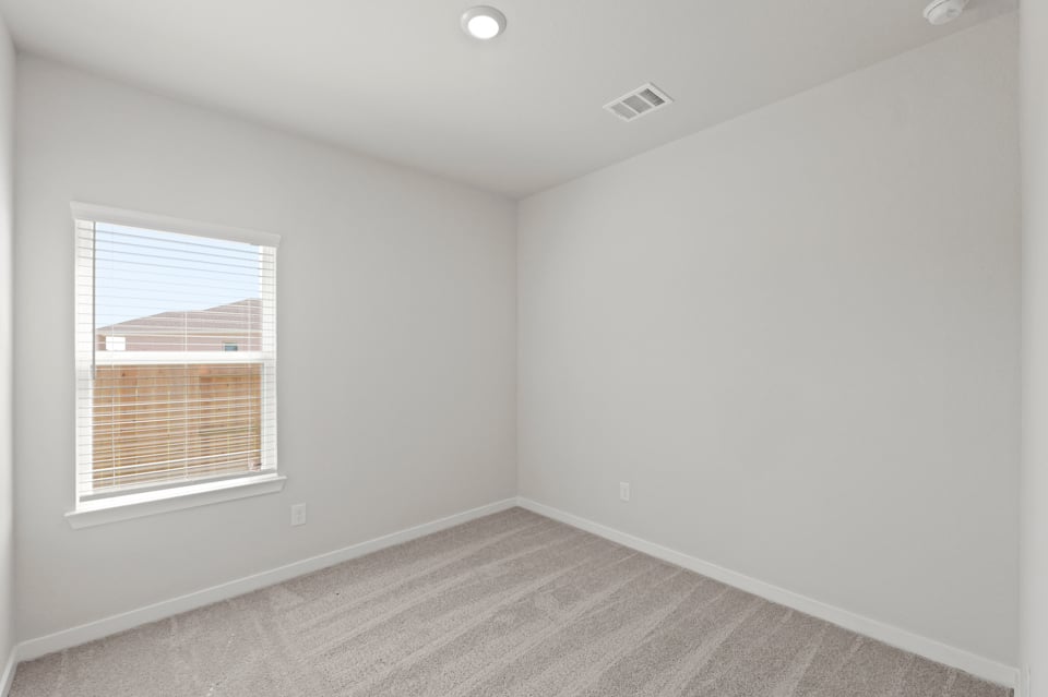 A room with a window and a carpet.