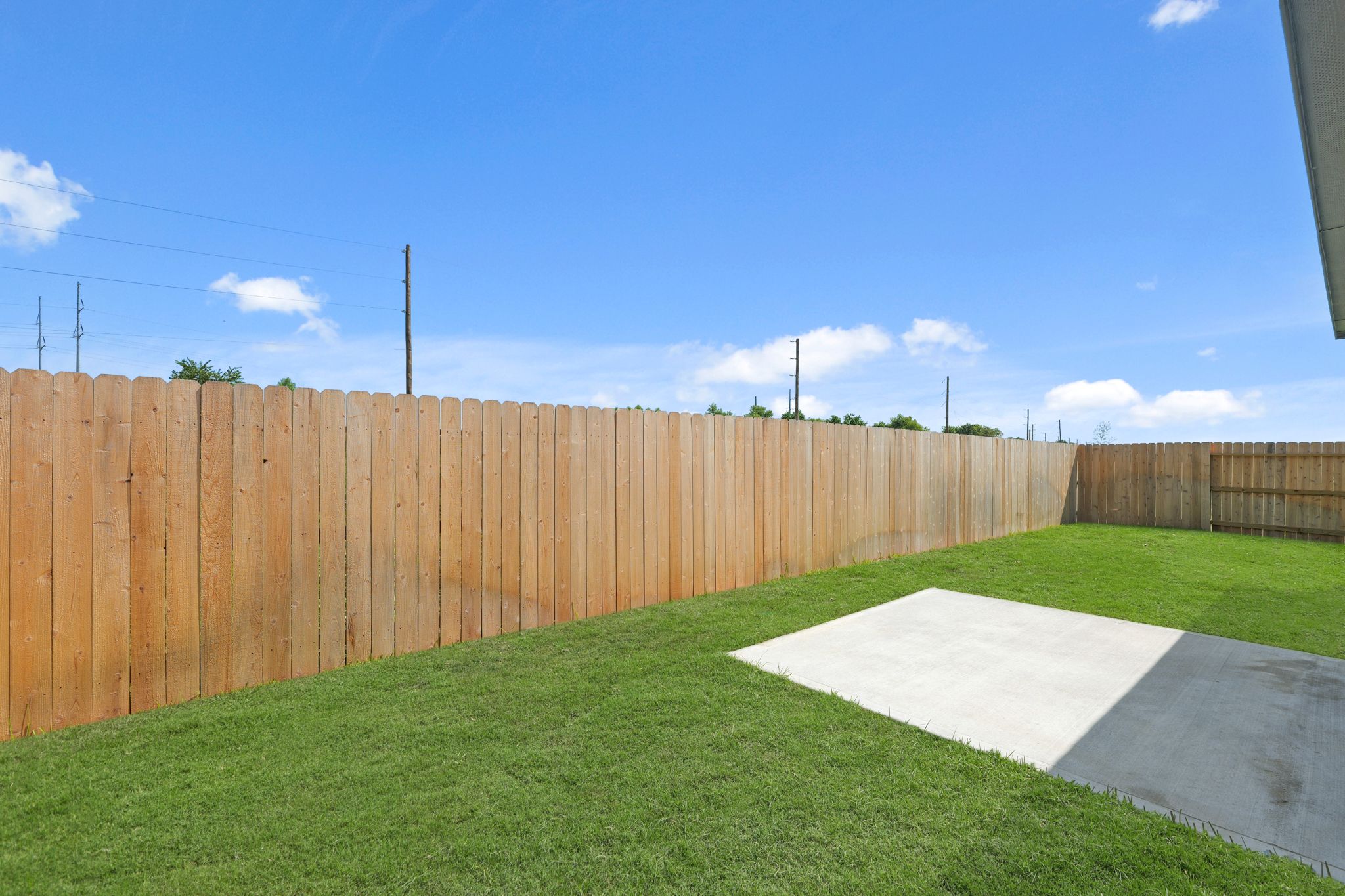 A fenced off area with a road and grass.