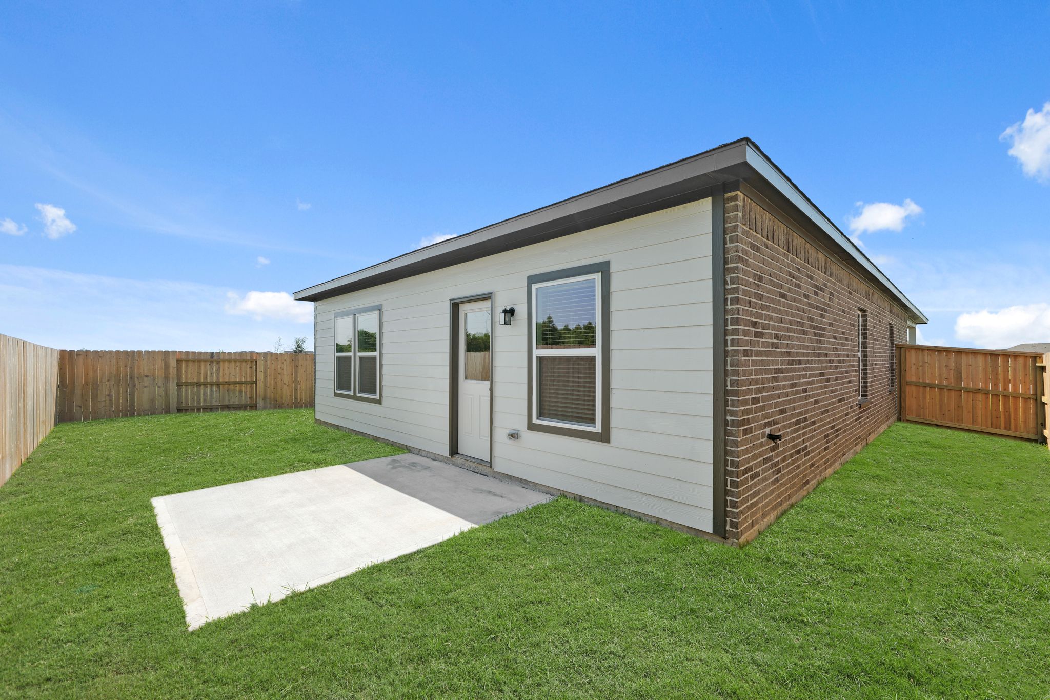 A house with a fence and grass.