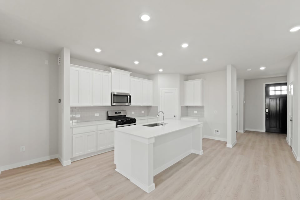 A kitchen with white cabinets.