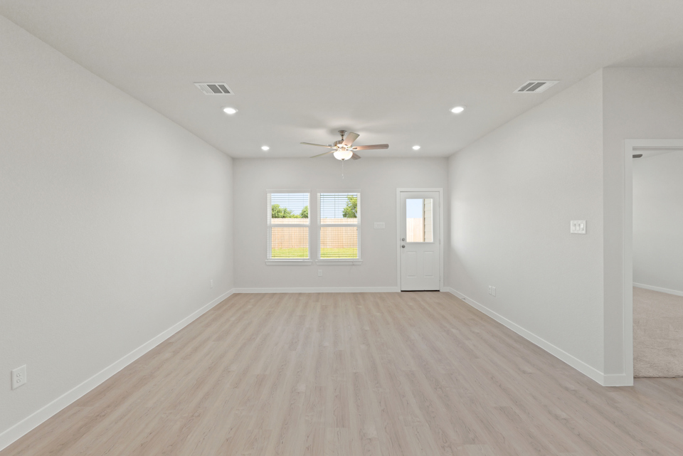 A room with a wood floor and a ceiling fan.
