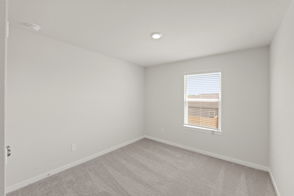 A room with a window and a carpet.