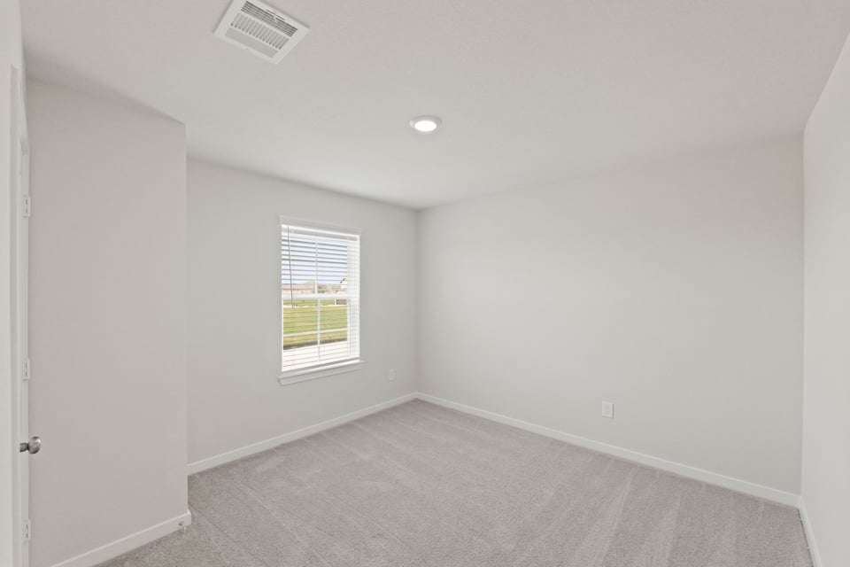 A room with a window and a carpet.