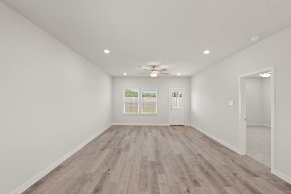 A room with a wood floor and a wood floor with a ceiling fan.