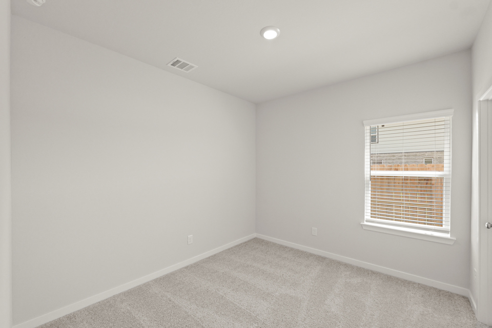 A room with a window and a carpet.