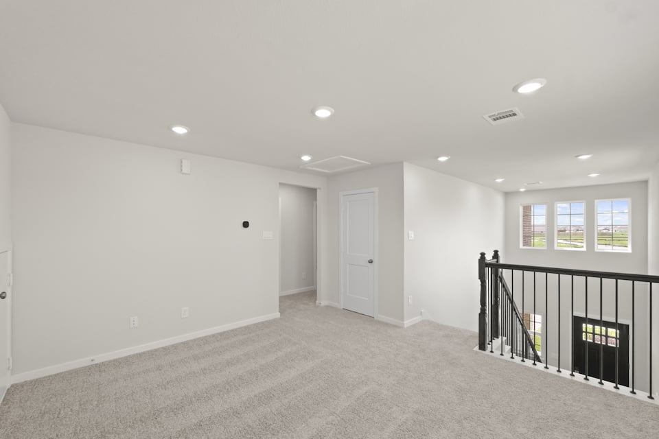 A room with a black railing and white walls.