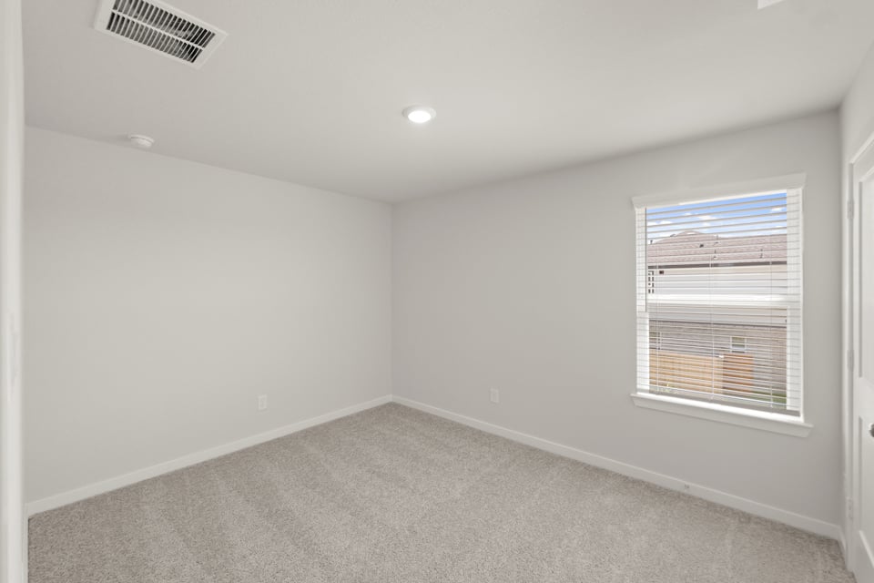 A room with a window and a carpet.