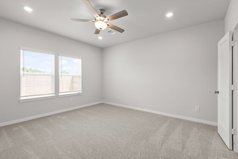 A room with a ceiling fan and a window.
