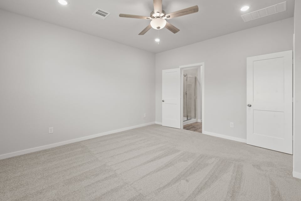 A room with a ceiling fan and a door.