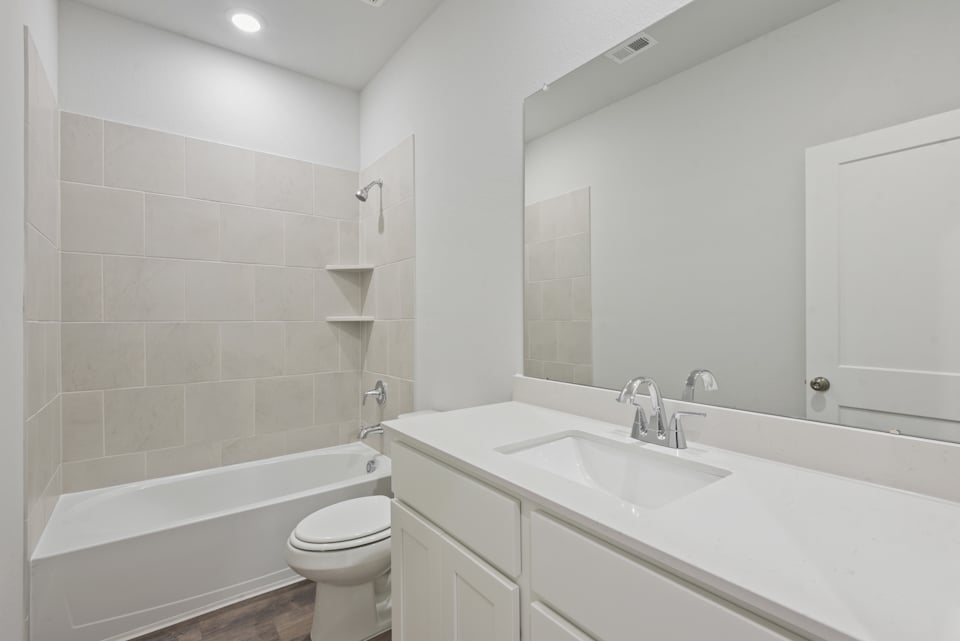A bathroom with a tub sink and toilet.