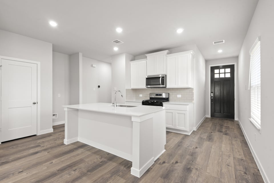 A kitchen with white cabinets.