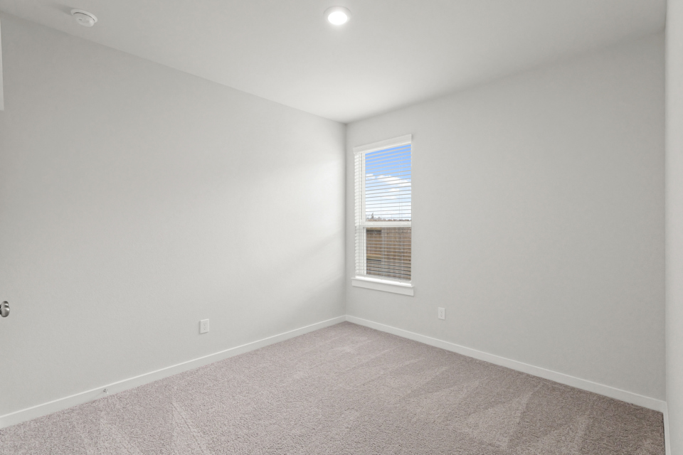 A room with a window and a carpet.