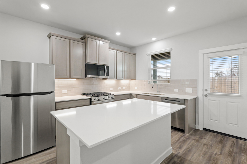 A kitchen with white cabinets.