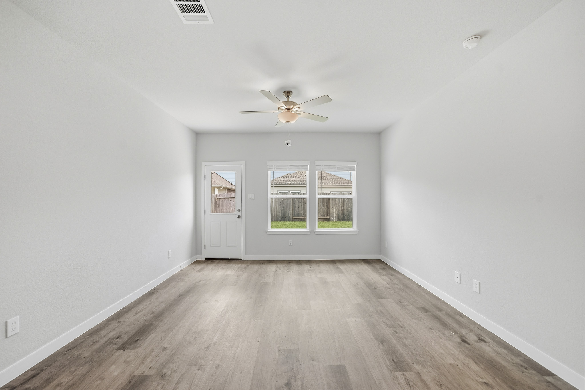 A room with a wood floor and a ceiling fan.