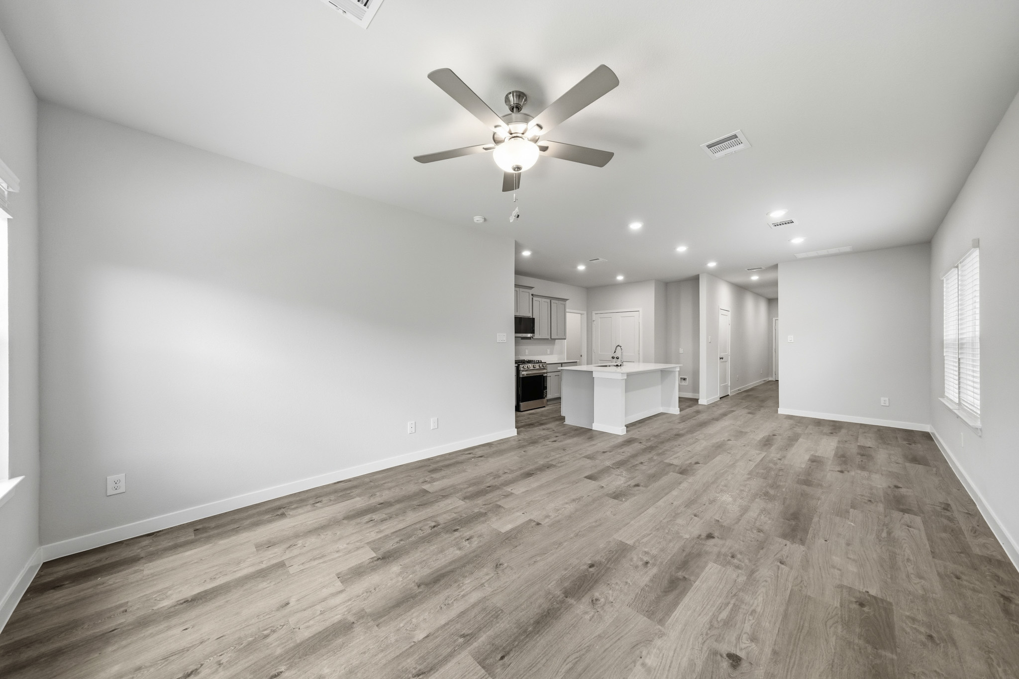 A room with a wood floor and a ceiling fan.