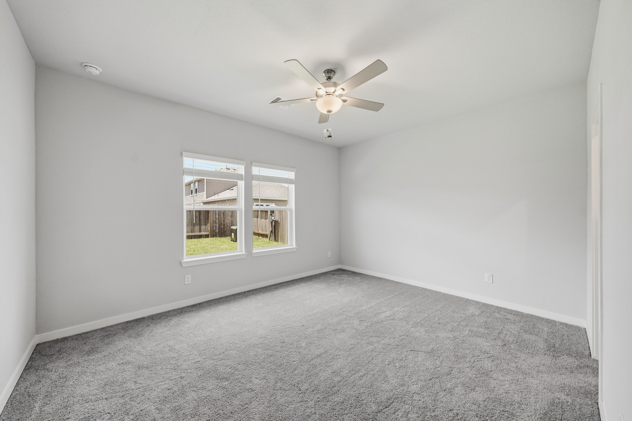 A room with a ceiling fan and a window.