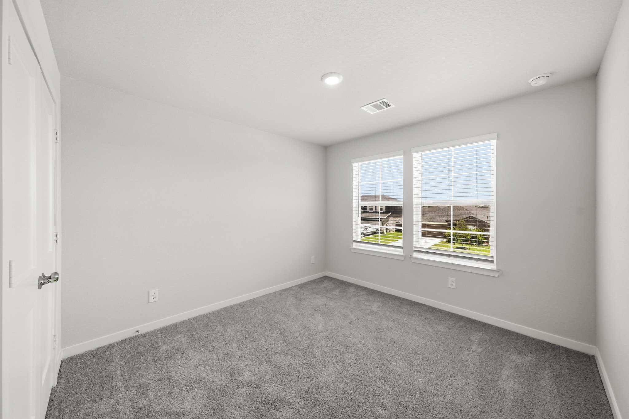 A room with a carpet and a window.