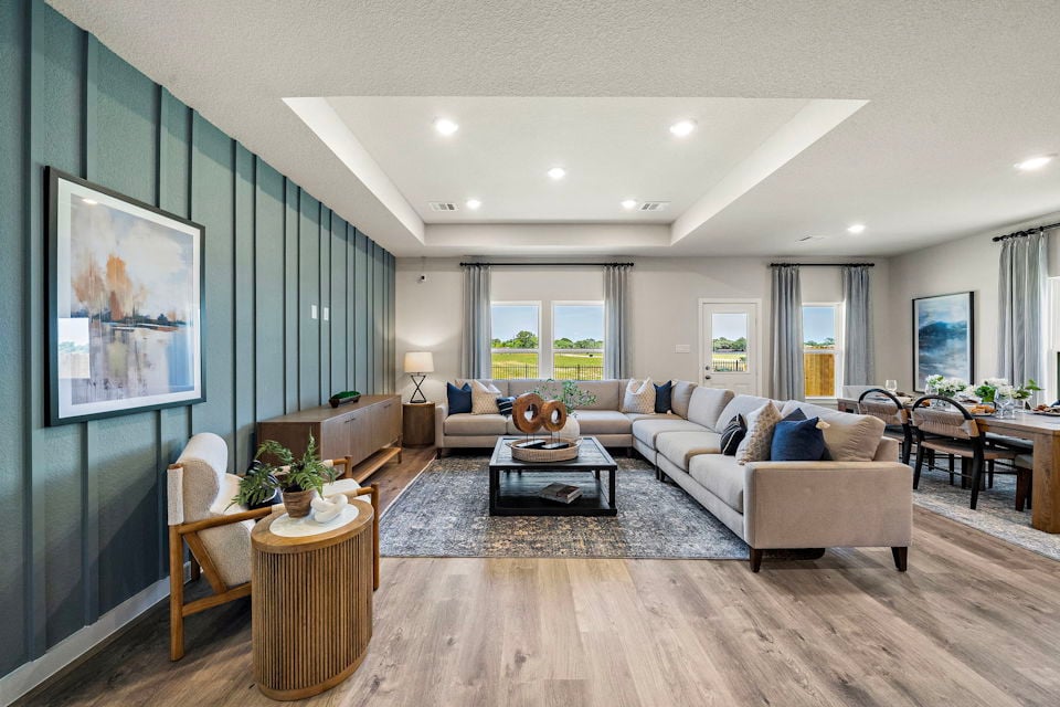 A living room with a large rug and a large window.