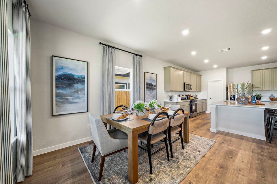 A dining room with a table and chairs.