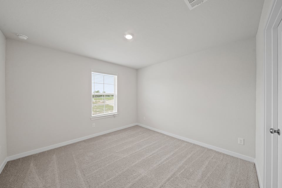 A room with a window and a carpet.