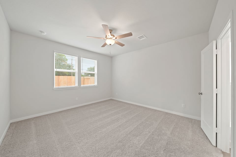A room with a ceiling fan and a window.