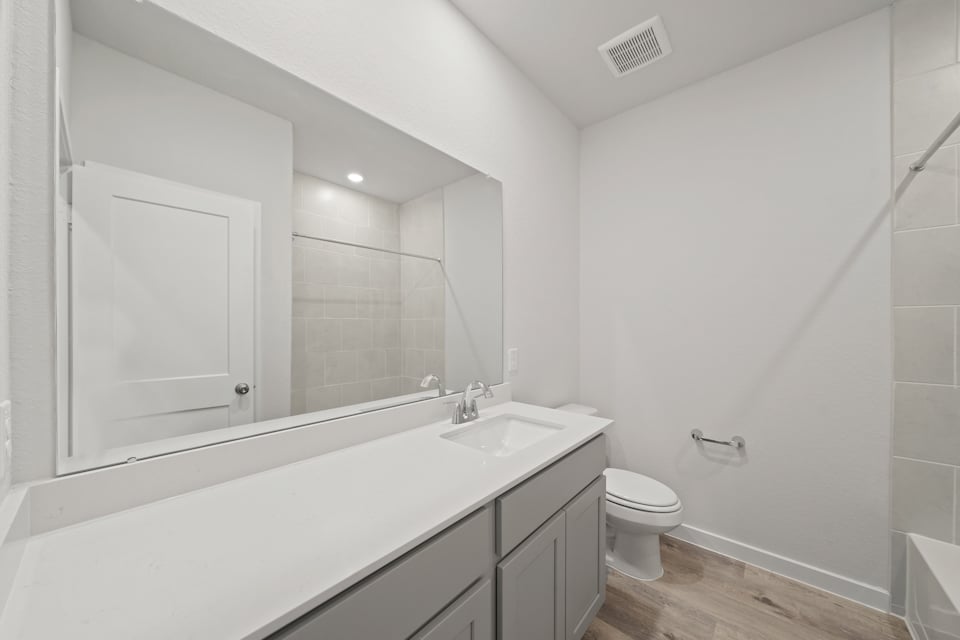 A bathroom with a tub sink and toilet.