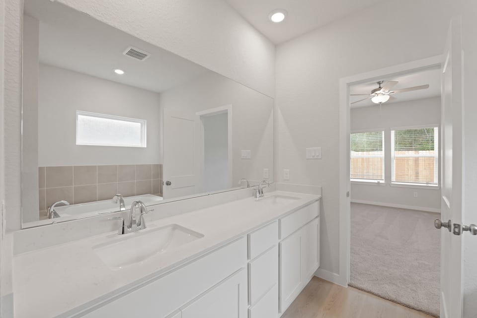 A bathroom with a large mirror.