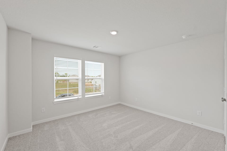 A room with a window and a carpet.