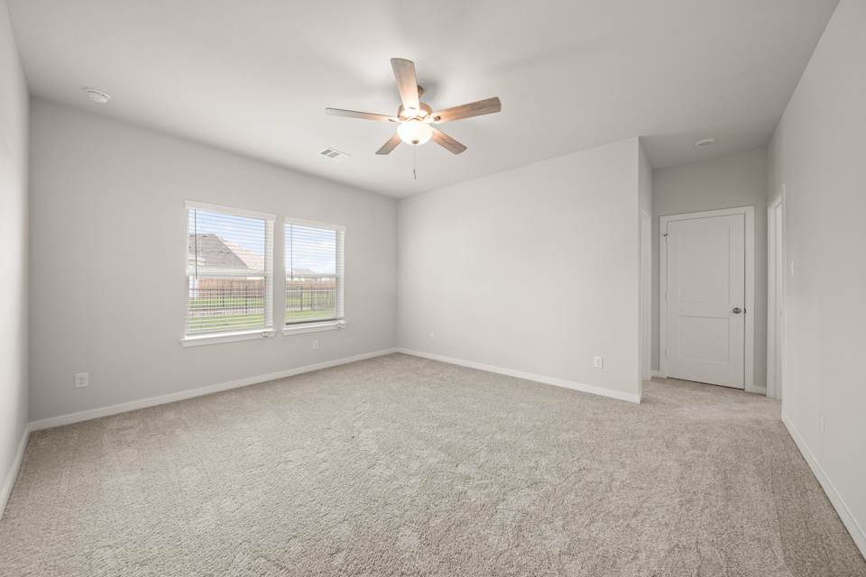 A room with a ceiling fan and a window.