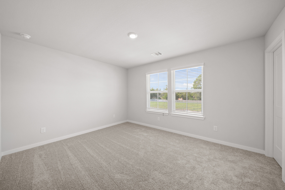 A room with a window and a carpet.