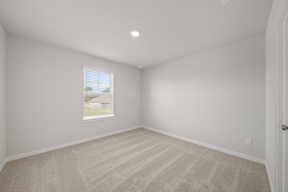 A room with a window and carpet.