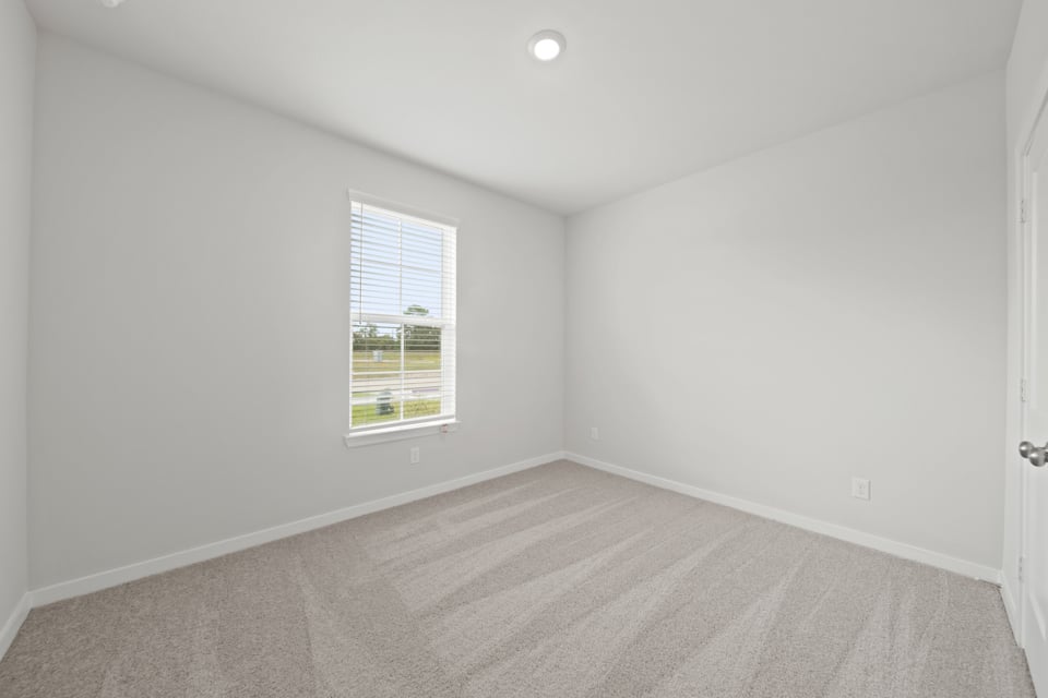 A room with a window and a carpet.