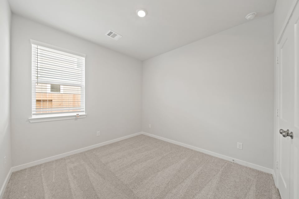 A room with a carpet and a window.