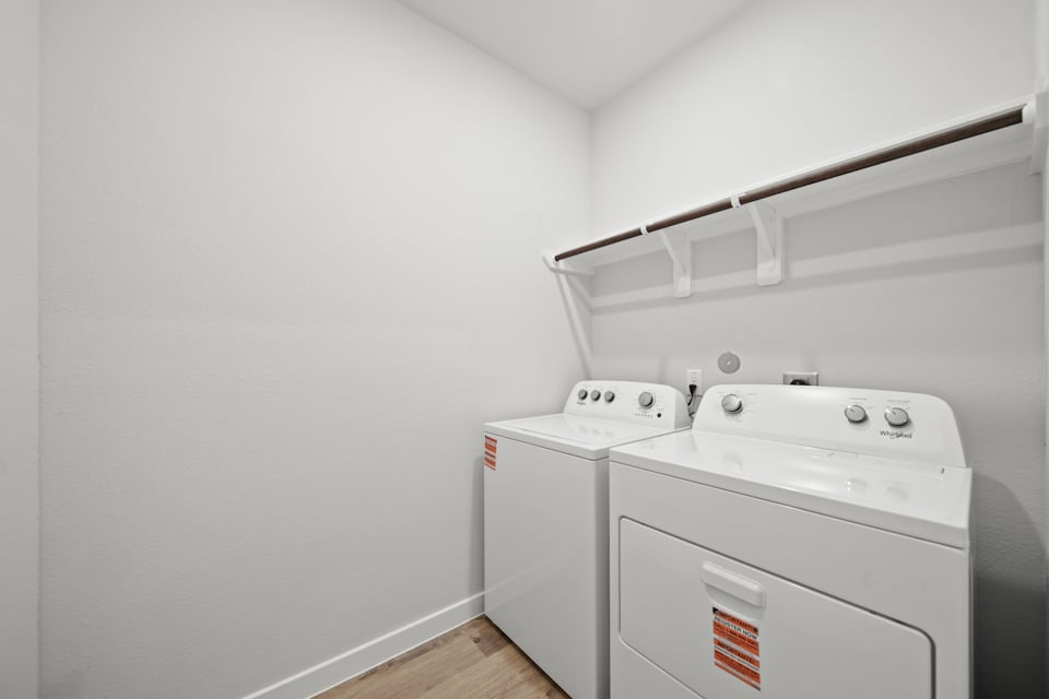 A white laundry room with a white laundry machine.