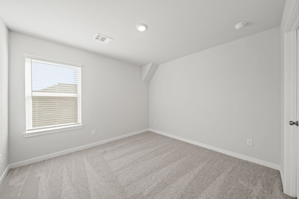A room with a carpet and windows.