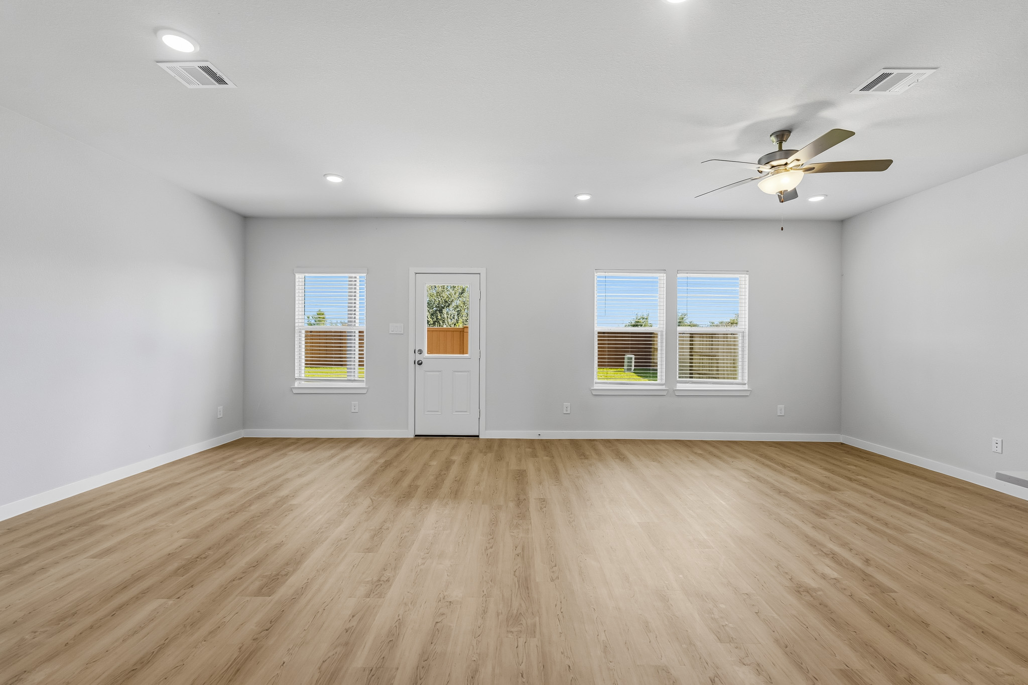 A room with a wood floor and a ceiling fan.