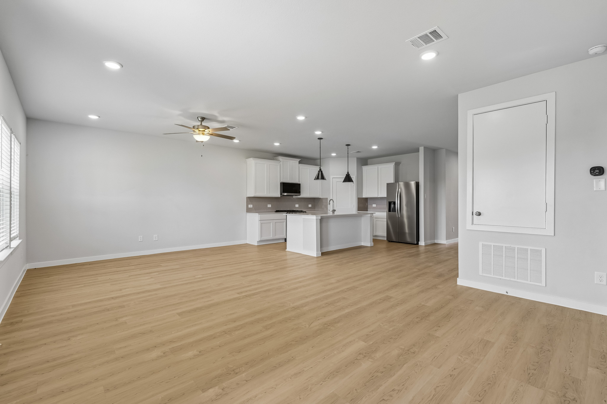 A large kitchen with a wood floor.