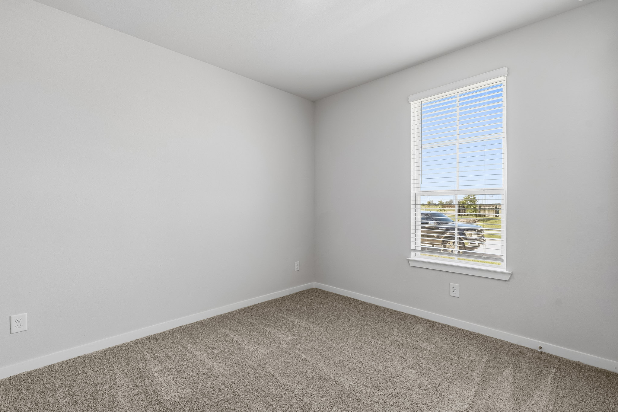 A room with a window and a carpet.