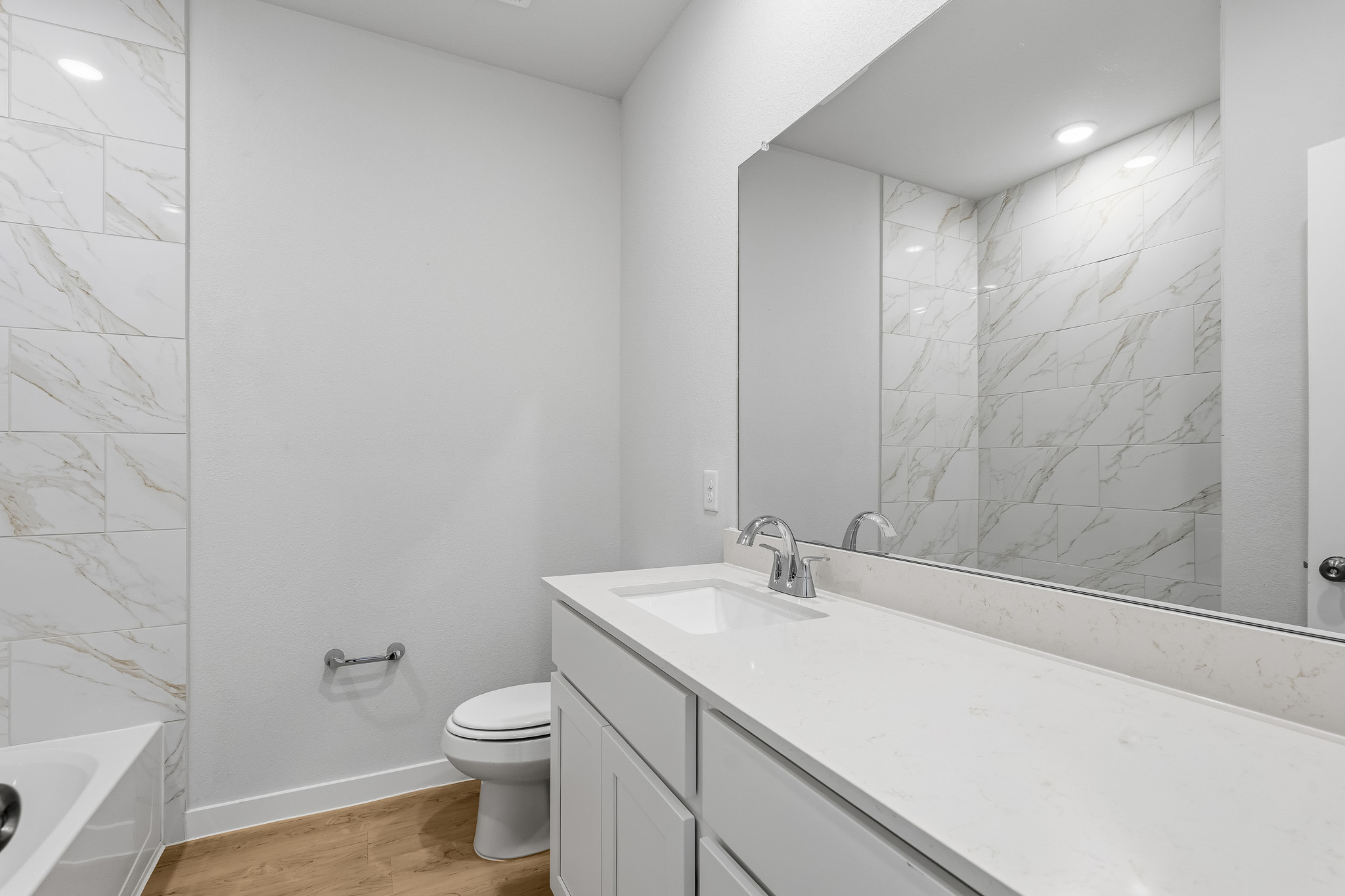 A bathroom with a tub sink and toilet.