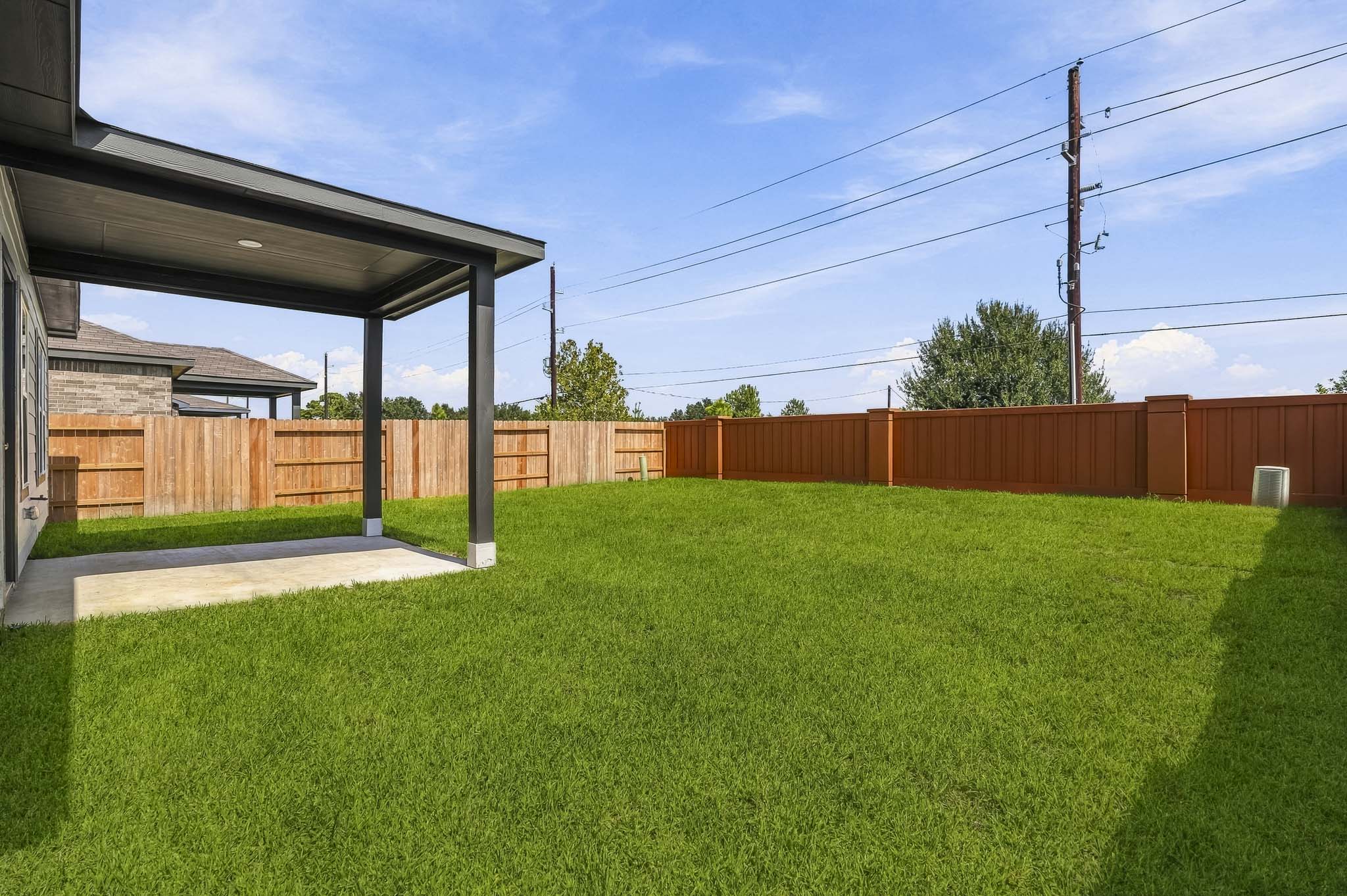A fenced in yard with a wood building and a wood fence.