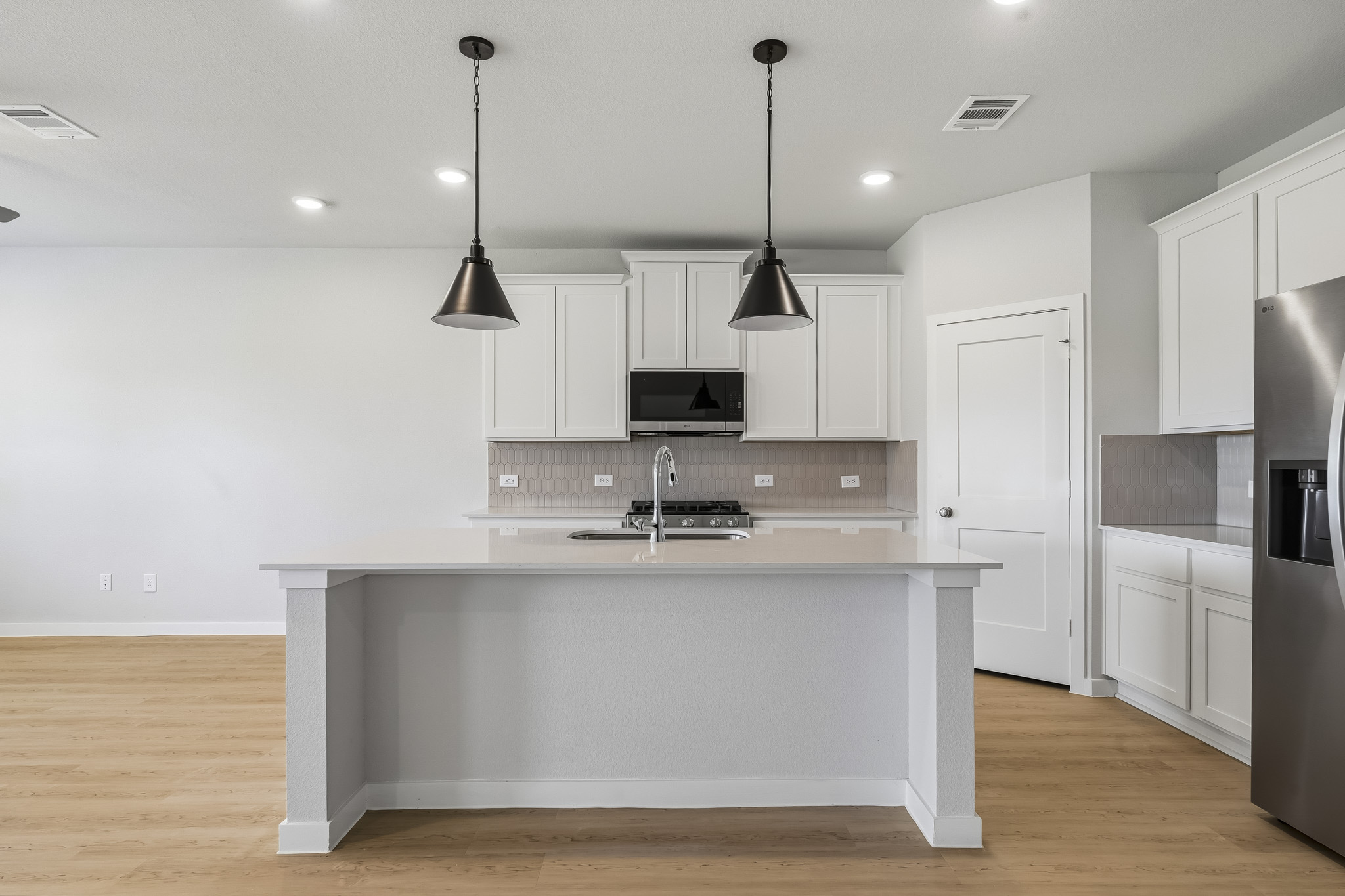 A kitchen with white cabinets.