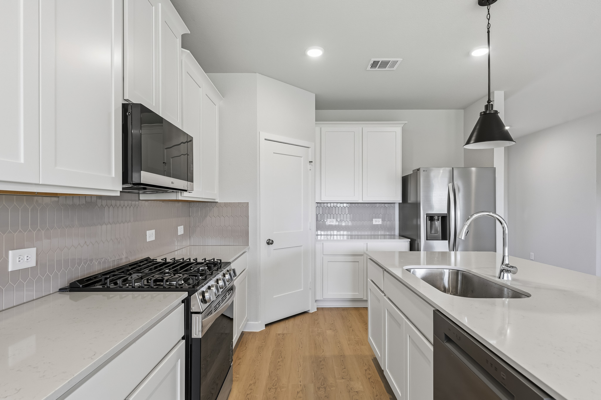 A kitchen with white cabinets.