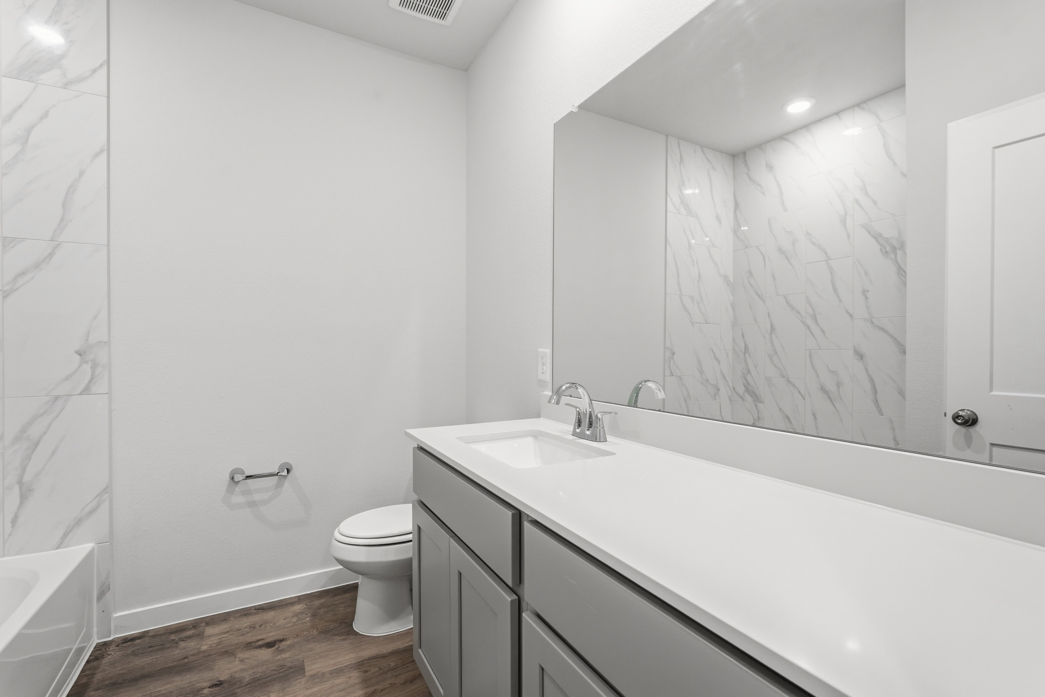 A bathroom with a tub sink and toilet.