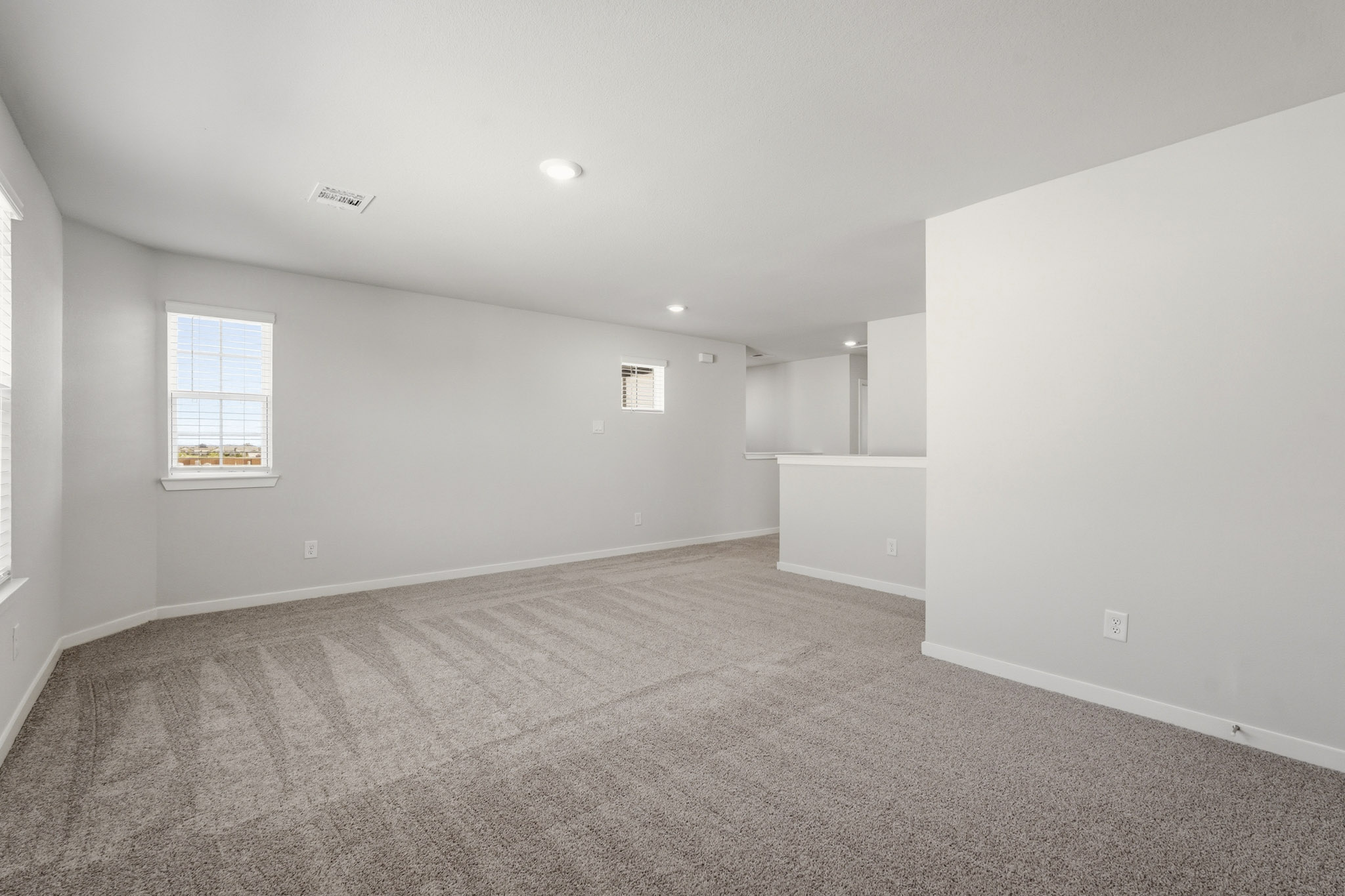 A room with a carpet and a window.