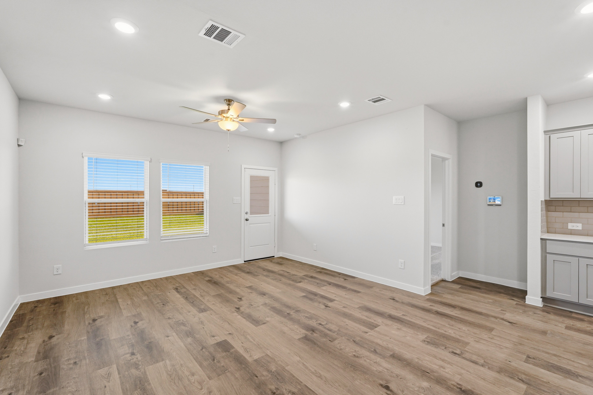 A room with a wood floor and a ceiling fan.