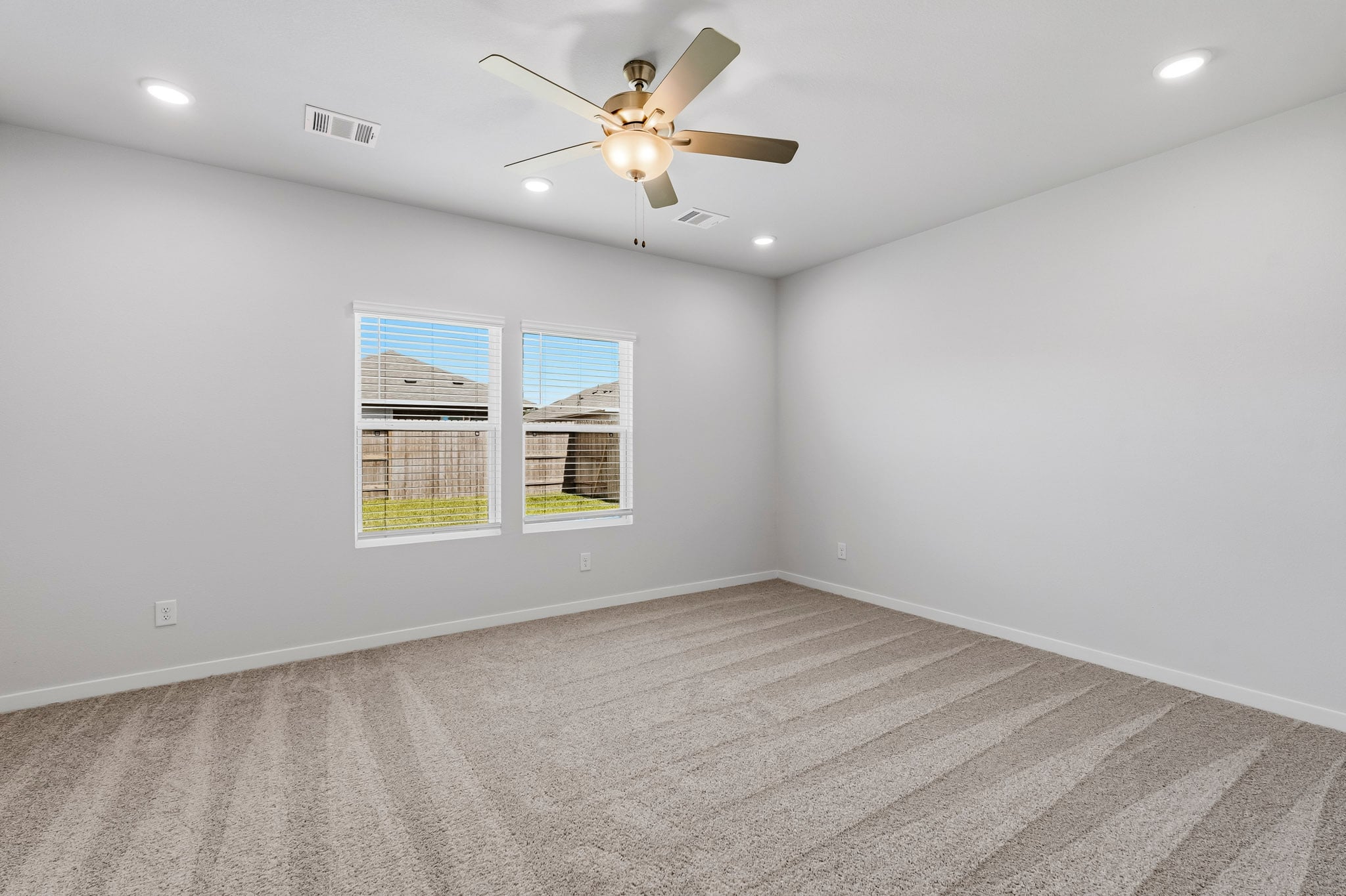 A room with a ceiling fan and a window.