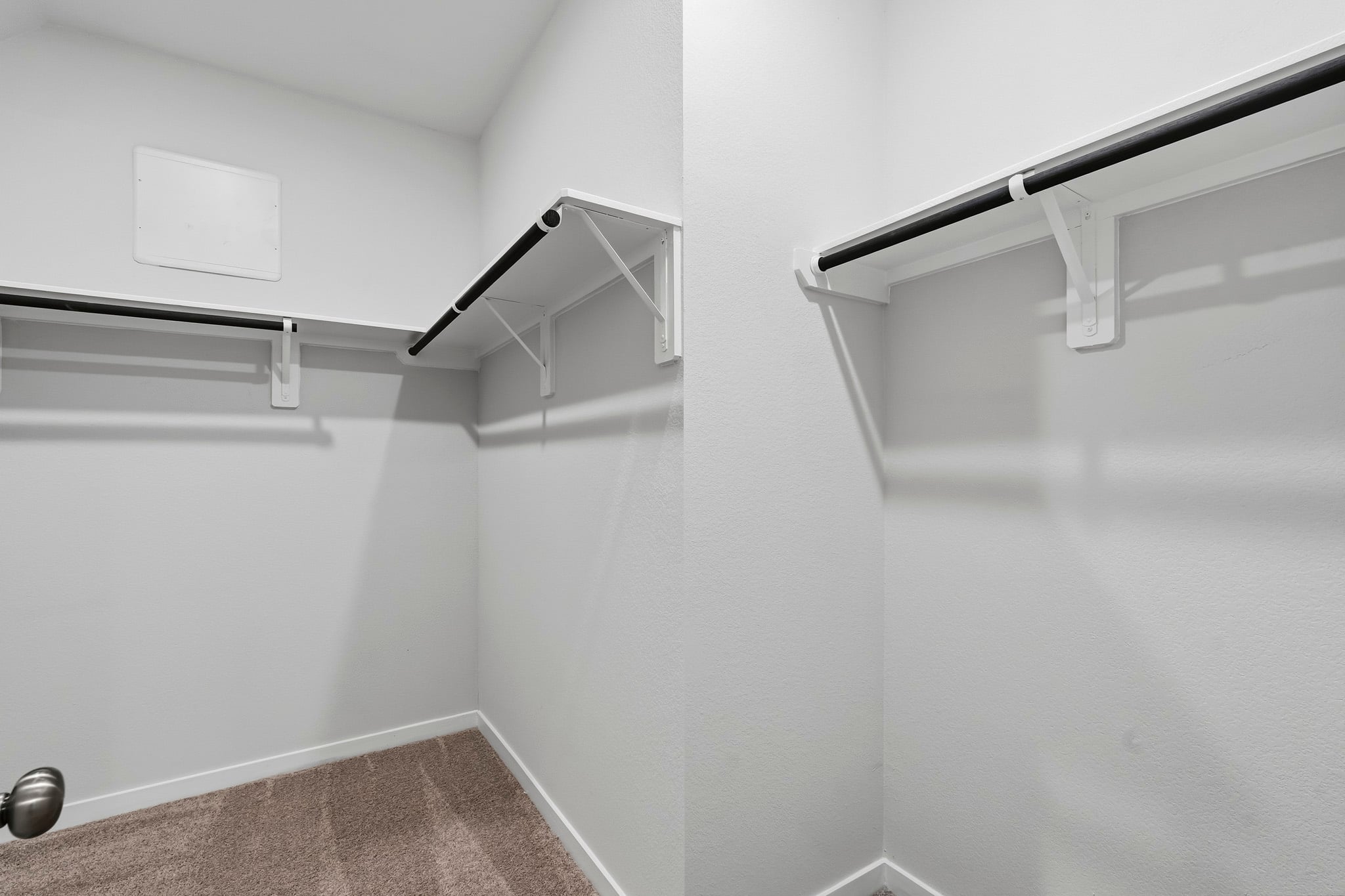A white wall with a metal bar.