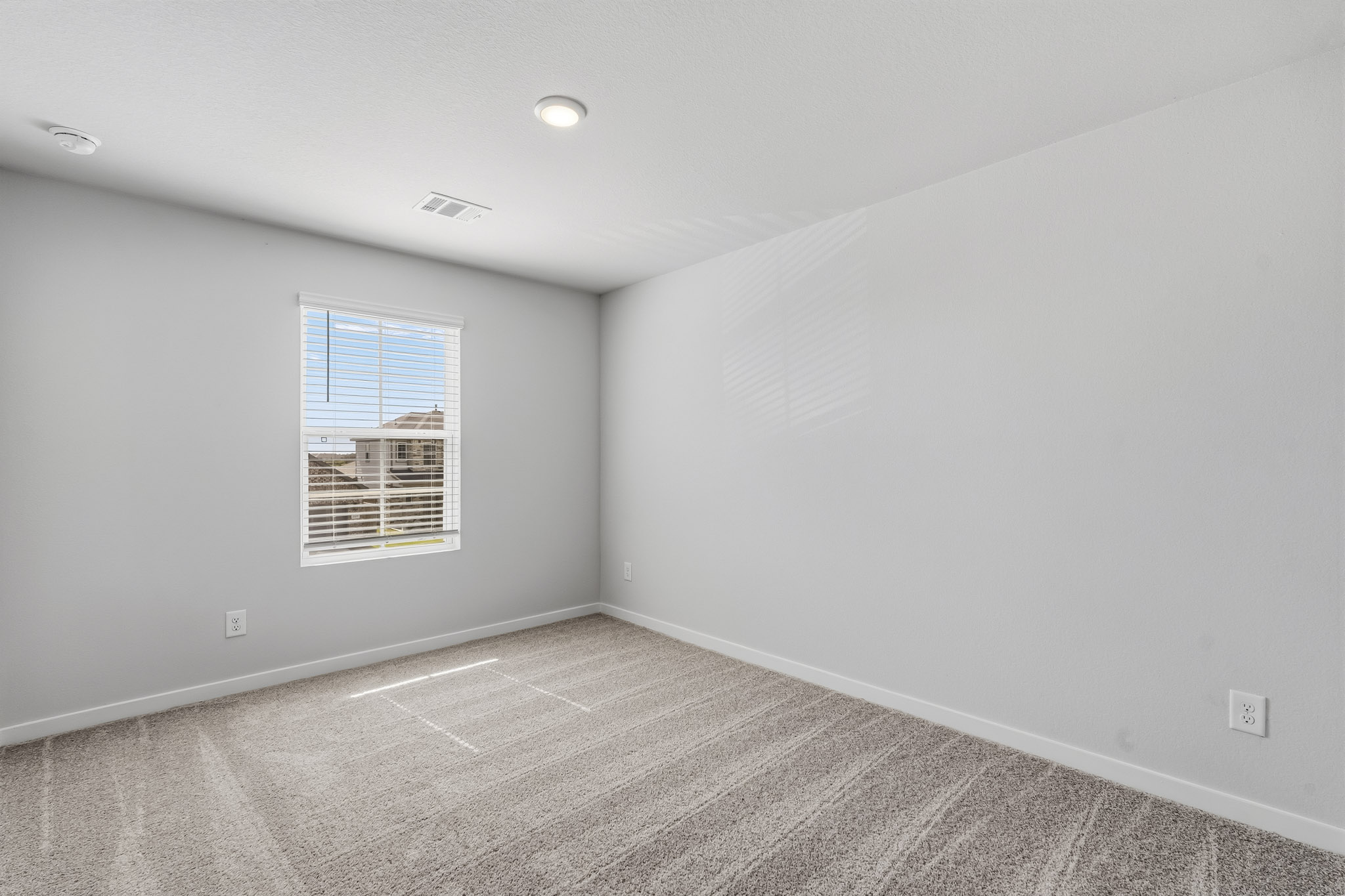 A room with a window and a carpet.