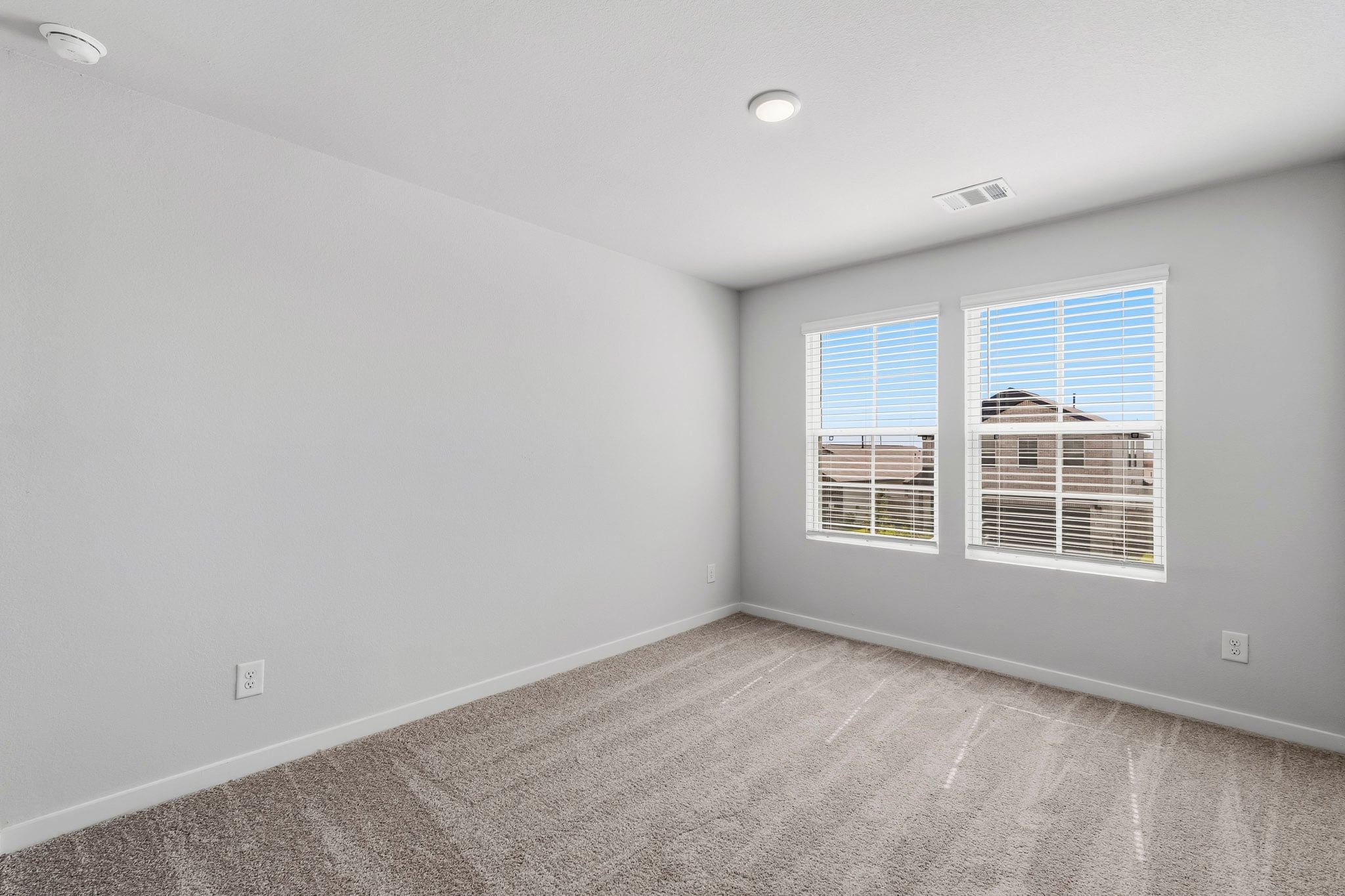 A room with a window and a carpet.