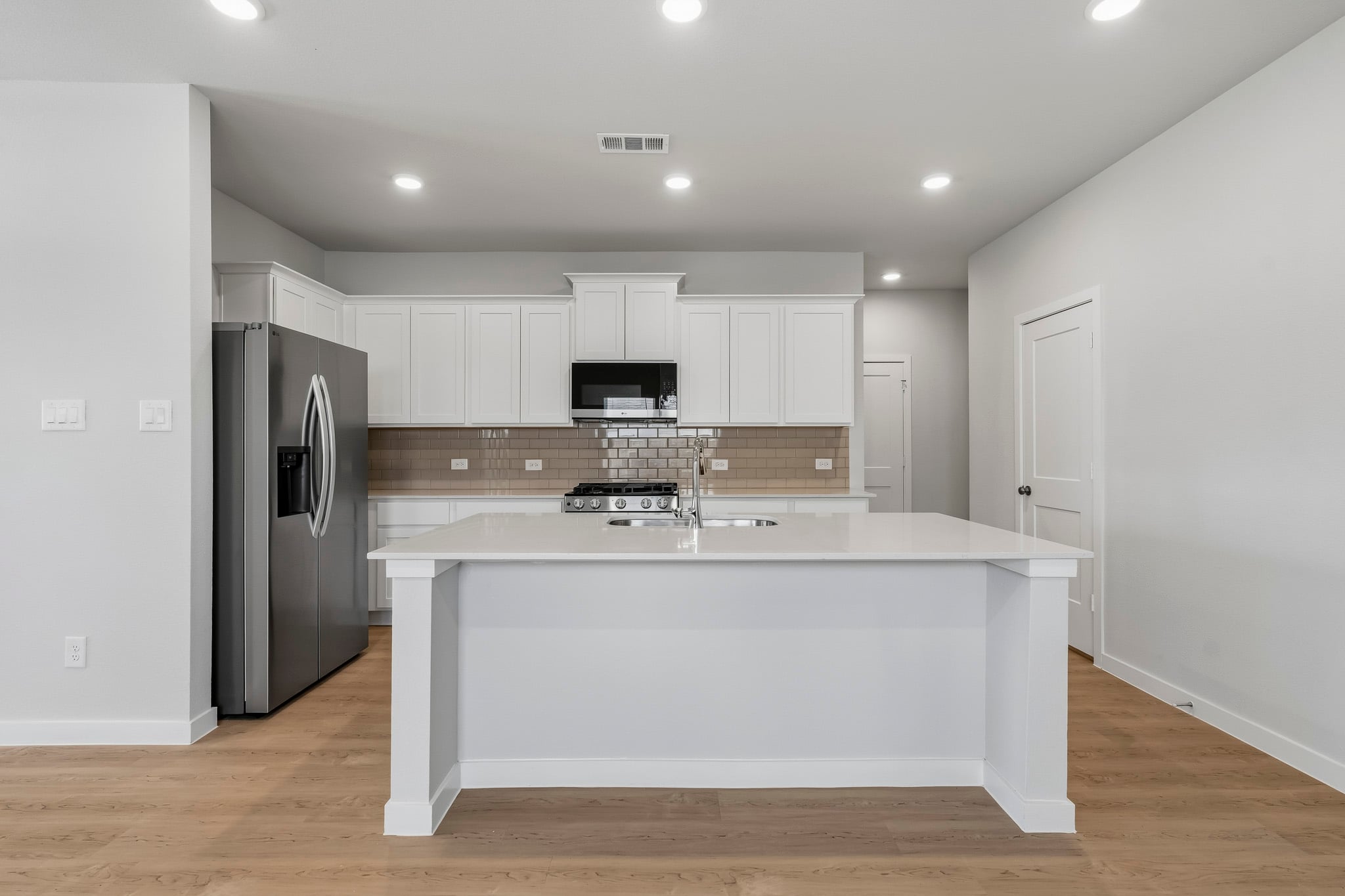 A kitchen with white cabinets.